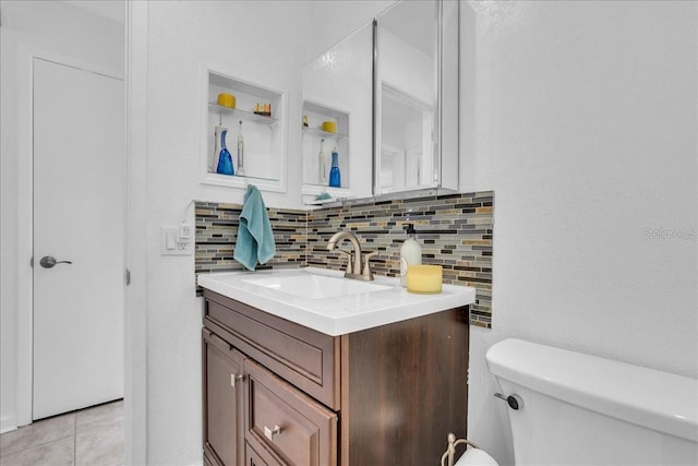 half bathroom with vanity, backsplash, and toilet