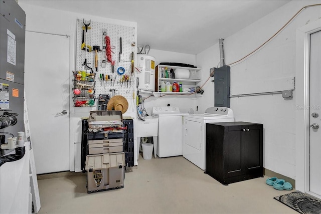 laundry room with washing machine and clothes dryer, electric panel, electric water heater, and laundry area