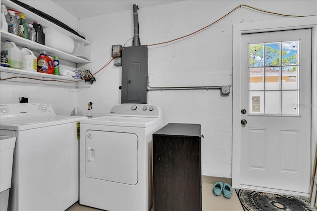 washroom with washing machine and clothes dryer, electric panel, and laundry area