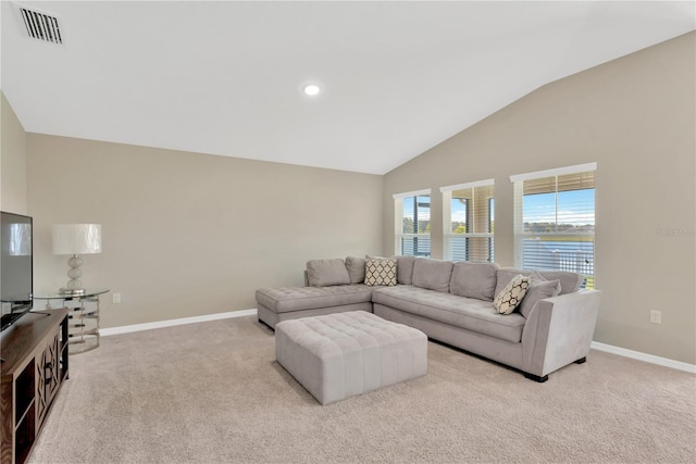 living room featuring a water view, light colored carpet, and lofted ceiling