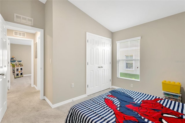 carpeted bedroom with lofted ceiling and a closet