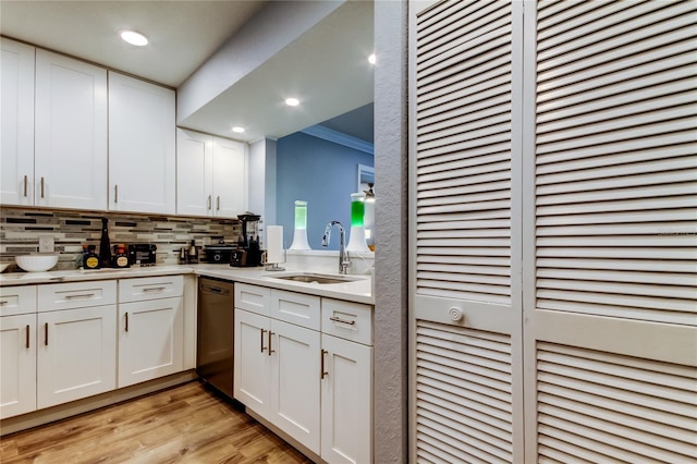 kitchen with white cabinetry, sink, crown molding, and black dishwasher