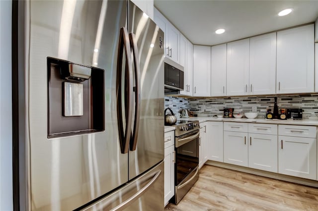 kitchen featuring appliances with stainless steel finishes, white cabinets, and decorative backsplash