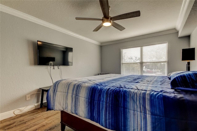 bedroom with hardwood / wood-style flooring, crown molding, ceiling fan, and a textured ceiling