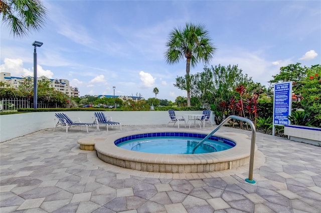 view of swimming pool with a hot tub and a patio