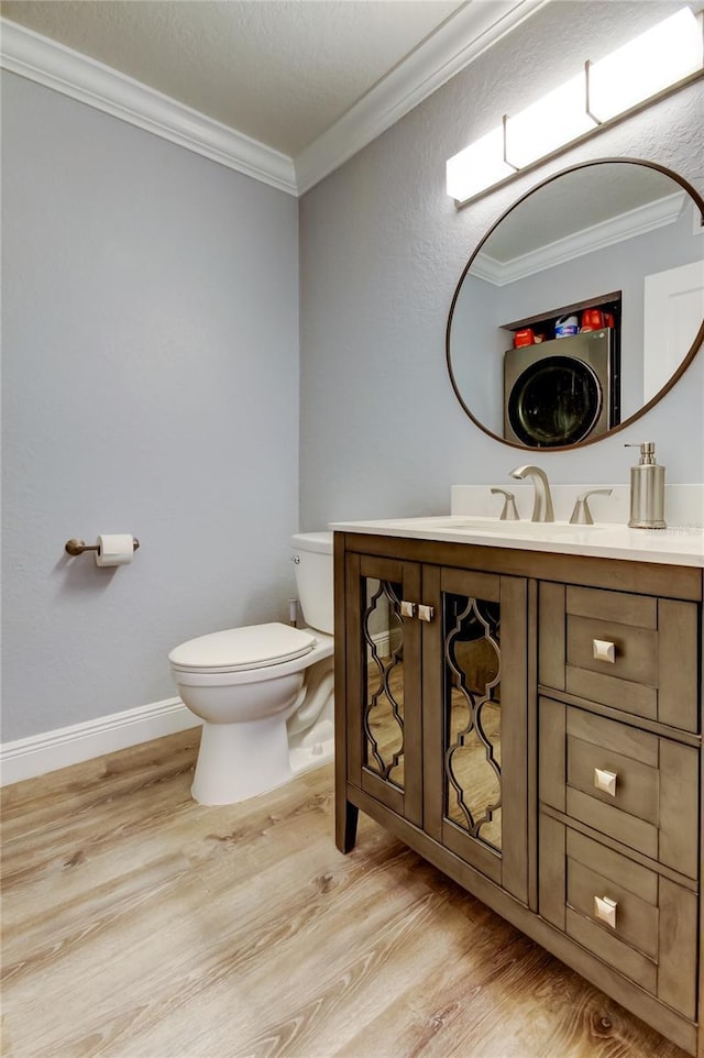 bathroom with vanity, hardwood / wood-style floors, ornamental molding, and toilet