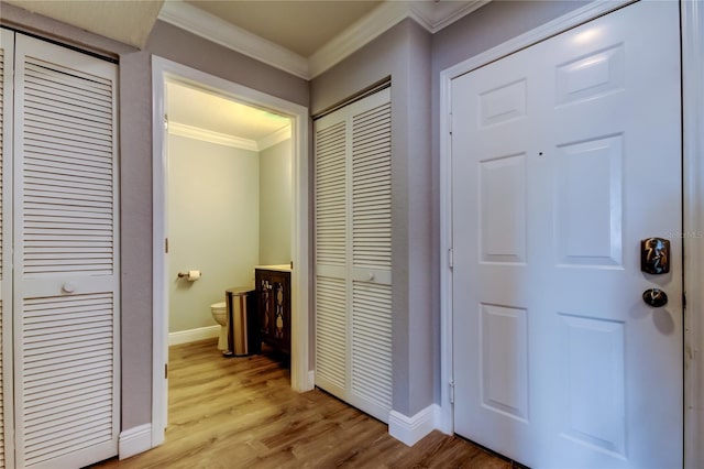 hall featuring crown molding and light hardwood / wood-style flooring