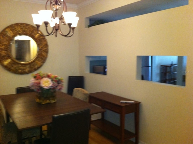 dining space featuring ornamental molding and a notable chandelier