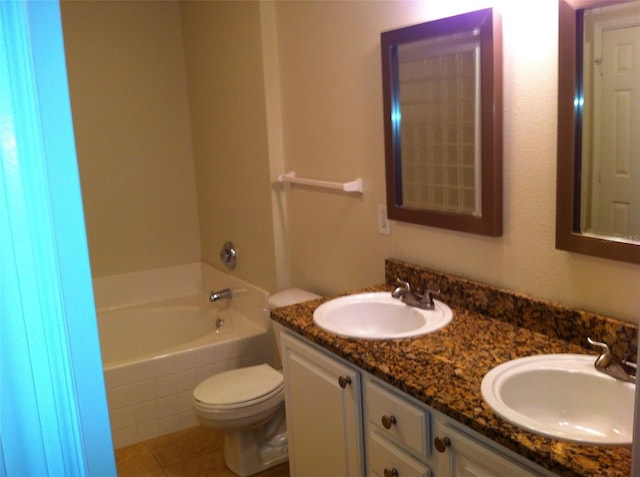 bathroom featuring vanity, toilet, tile patterned flooring, and tiled tub