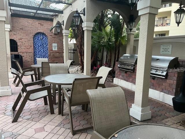 view of patio / terrace featuring exterior kitchen, area for grilling, and a pergola