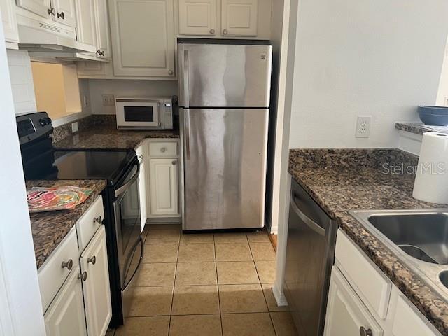 501 Knights Run Ave Unit 2119, Tampa, FL 33602 - kitchen with appliances with stainless steel finishes, under cabinet range hood, white cabinets, and light tile patterned floors