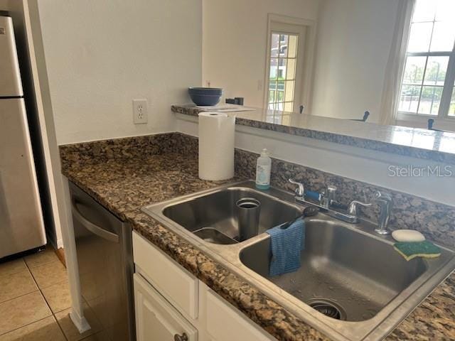 501 Knights Run Ave Unit 2119, Tampa, FL 33602 - kitchen featuring appliances with stainless steel finishes, white cabinetry, dark stone counters, and light tile patterned floors
