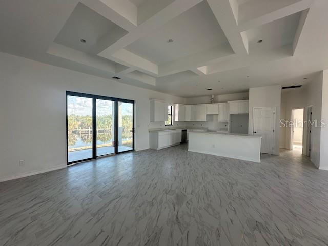 unfurnished living room featuring coffered ceiling