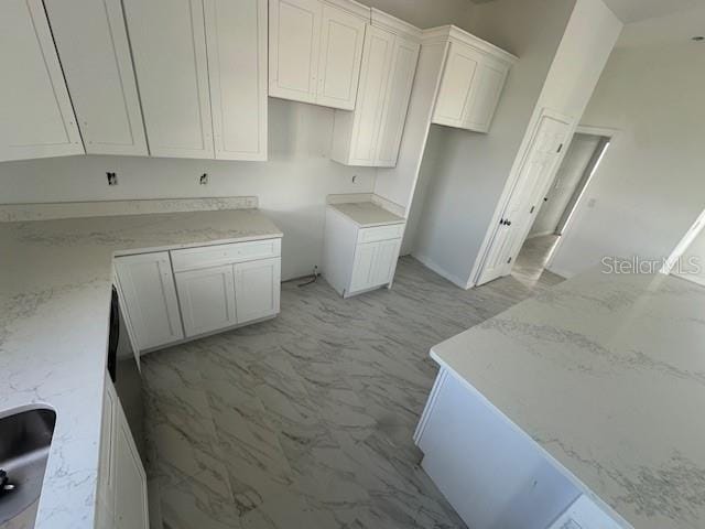 kitchen with light stone counters and white cabinets