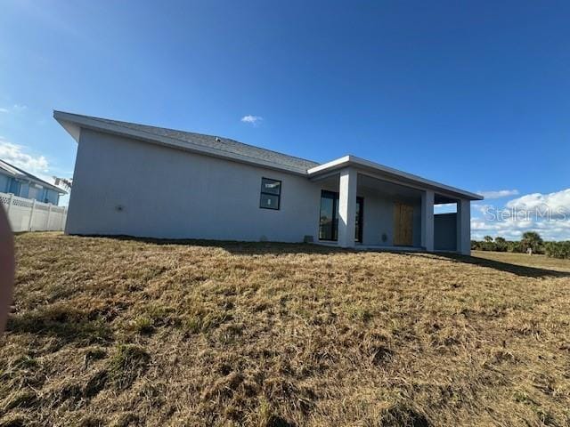 back of house featuring a lawn