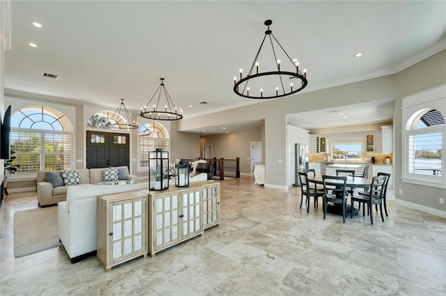 living room with an inviting chandelier and crown molding