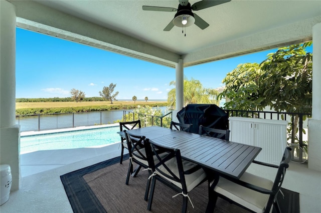 view of patio / terrace with a fenced in pool, a grill, ceiling fan, and a water view