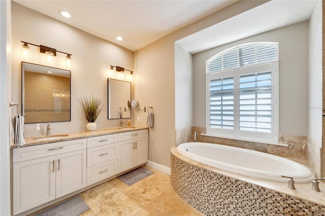 bathroom with a relaxing tiled tub and vanity