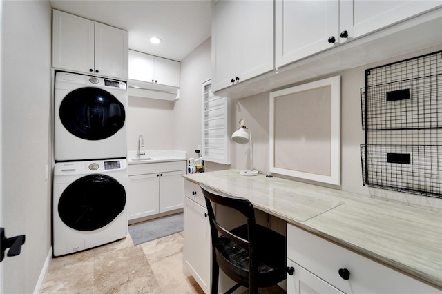 clothes washing area featuring cabinets, stacked washer and dryer, and sink