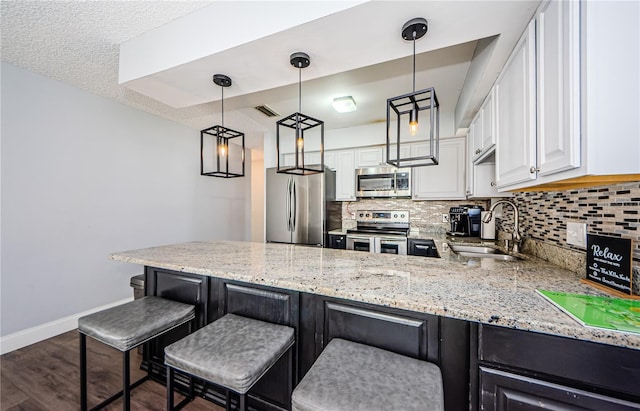 kitchen featuring stainless steel appliances, tasteful backsplash, a sink, and light stone counters