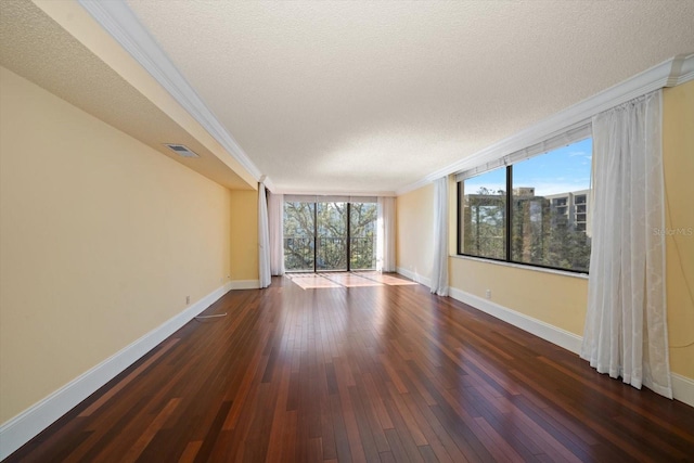 empty room featuring dark hardwood / wood-style flooring, crown molding, floor to ceiling windows, and a textured ceiling