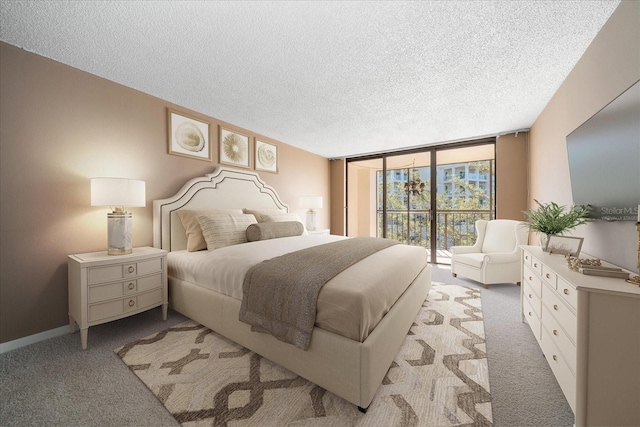 bedroom featuring a textured ceiling, light colored carpet, access to exterior, and a wall of windows