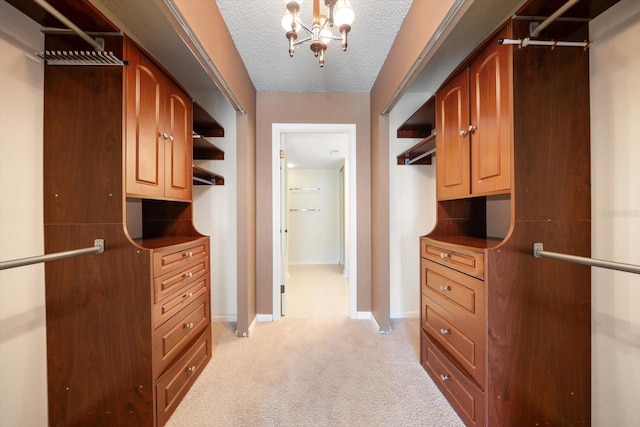 spacious closet featuring a chandelier and light carpet