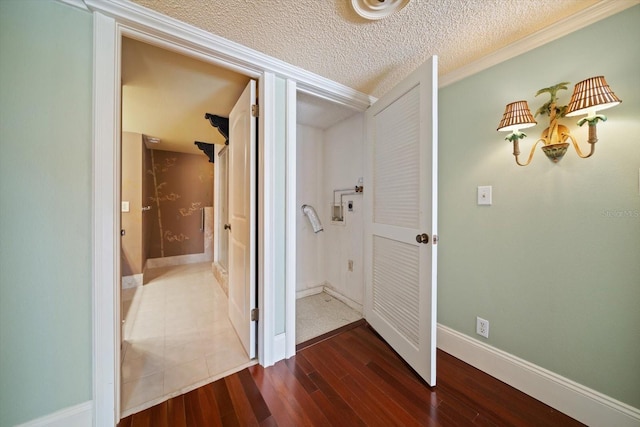 hall with ornamental molding, dark hardwood / wood-style flooring, and a textured ceiling