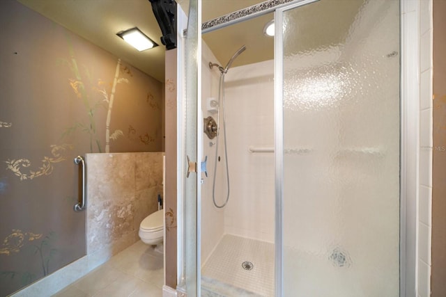 bathroom featuring walk in shower, tile patterned floors, and toilet