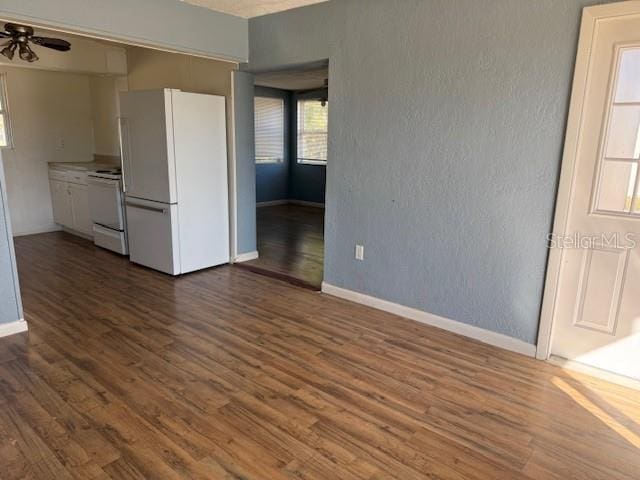 unfurnished living room with dark wood-type flooring and ceiling fan