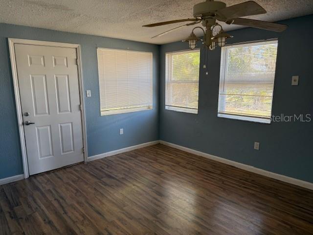 interior space with ceiling fan, dark wood-type flooring, and a textured ceiling