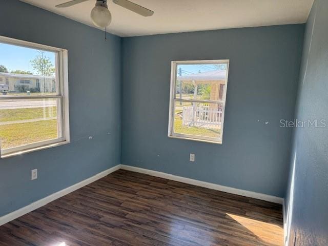 spare room featuring a wealth of natural light, dark hardwood / wood-style floors, and ceiling fan