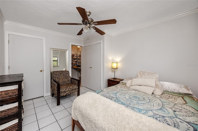 bedroom featuring light tile patterned flooring, a textured ceiling, ornamental molding, a closet, and ceiling fan