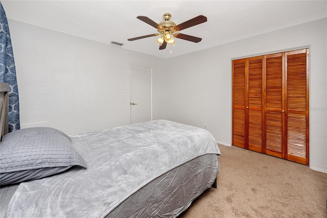 bedroom featuring ceiling fan, light colored carpet, and a closet