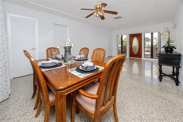 dining area with light speckled floor, visible vents, and a ceiling fan