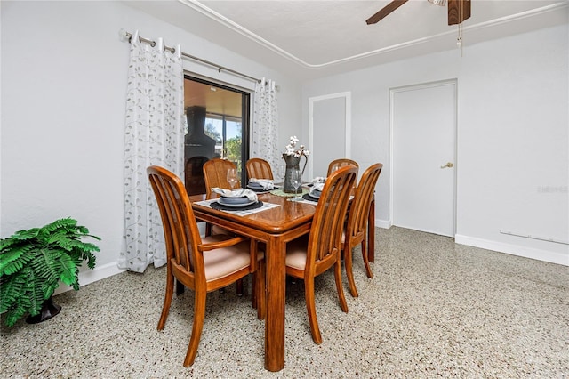 dining area featuring baseboards, a ceiling fan, and speckled floor