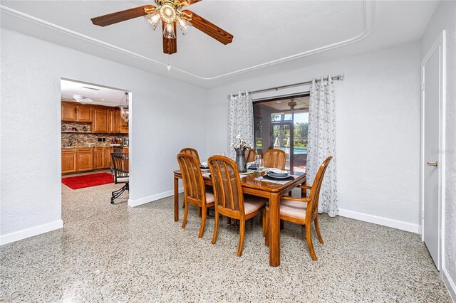 dining room with ceiling fan, light speckled floor, and baseboards