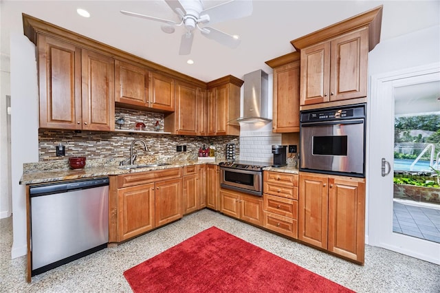 kitchen with wall chimney range hood, a sink, appliances with stainless steel finishes, and brown cabinets