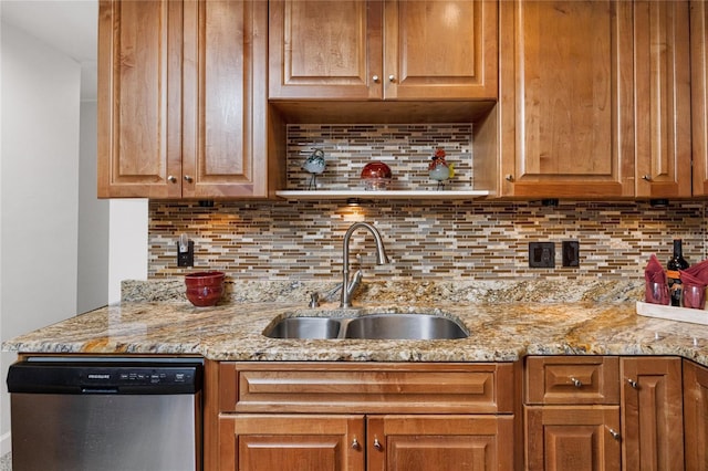 kitchen with light stone counters, a sink, backsplash, and stainless steel dishwasher