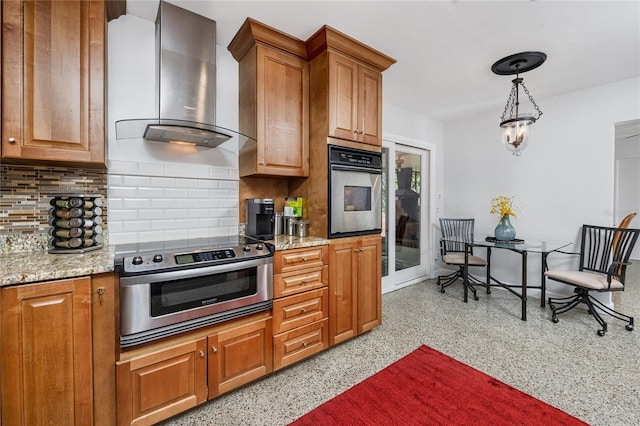 kitchen featuring light speckled floor, brown cabinets, stainless steel oven, wall chimney range hood, and range