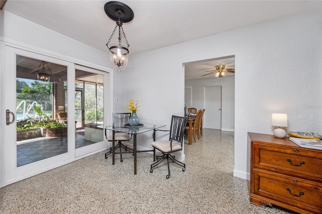 dining space featuring baseboards, light speckled floor, and a notable chandelier