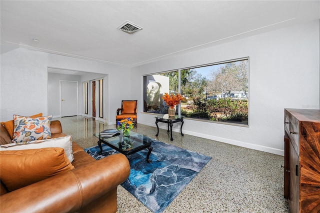 living area featuring baseboards, visible vents, and speckled floor