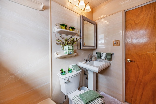 bathroom with a notable chandelier and toilet