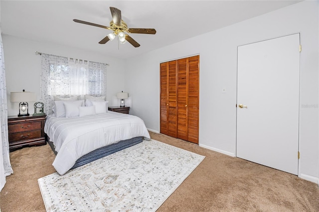 bedroom featuring light carpet, a closet, a ceiling fan, and baseboards