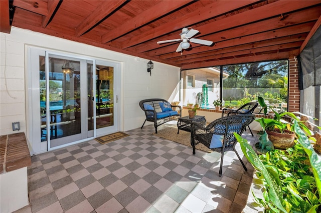 unfurnished sunroom with wood ceiling, a ceiling fan, and a healthy amount of sunlight