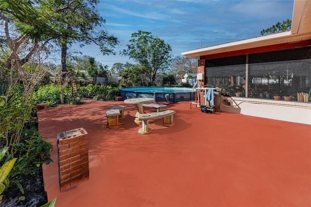 view of patio featuring a sunroom and an outdoor pool