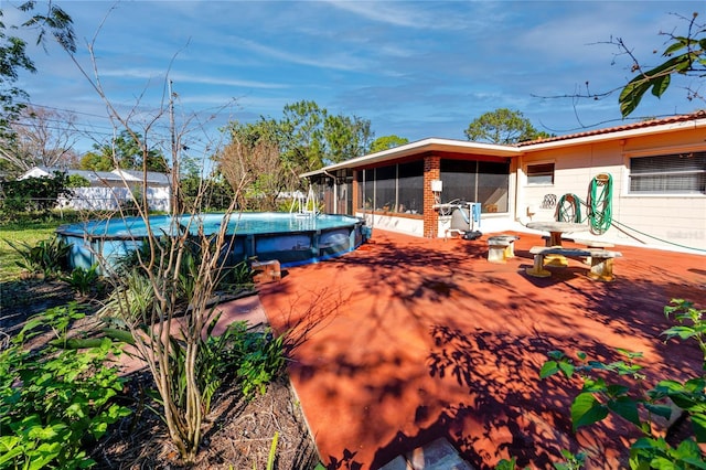 exterior space with a sunroom and an outdoor pool