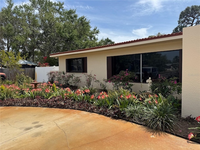 6226 Hampton Ct N, Saint Petersburg, FL 33710 - view of side of home featuring a patio area, a tiled roof, stucco siding, and fence