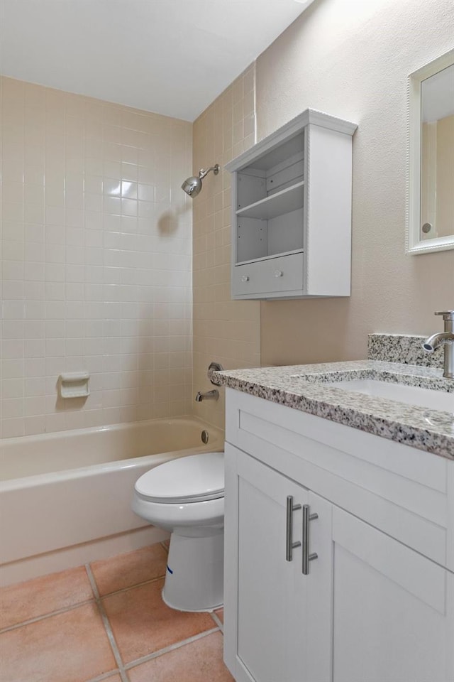 full bathroom featuring vanity, tiled shower / bath combo, tile patterned floors, and toilet