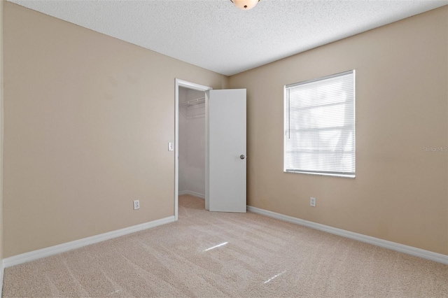 empty room featuring light carpet and a textured ceiling